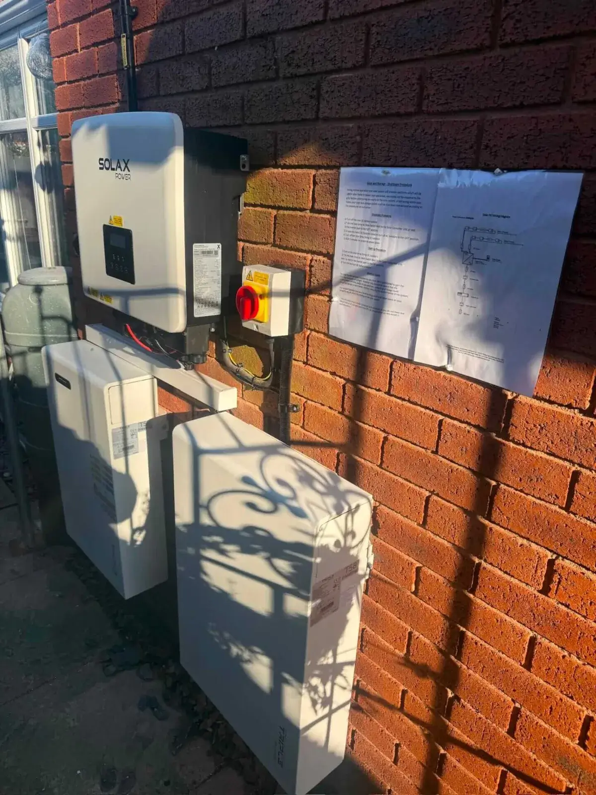 SolaX hybrid inverter and battery storage system installed on an exterior wall by Ashware Electrical